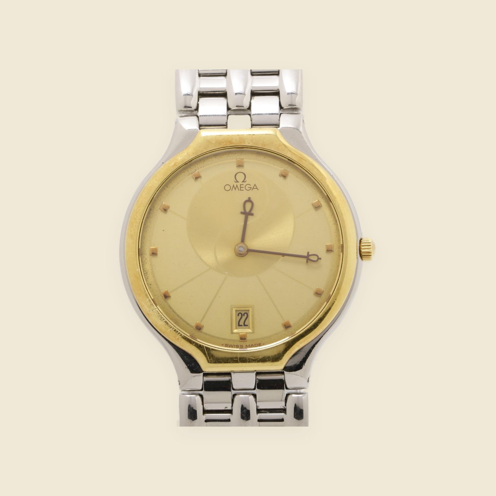 Orologio Omega De Ville in acciaio con quadrante champagne, lunetta dorata e bracciale a maglie integrato