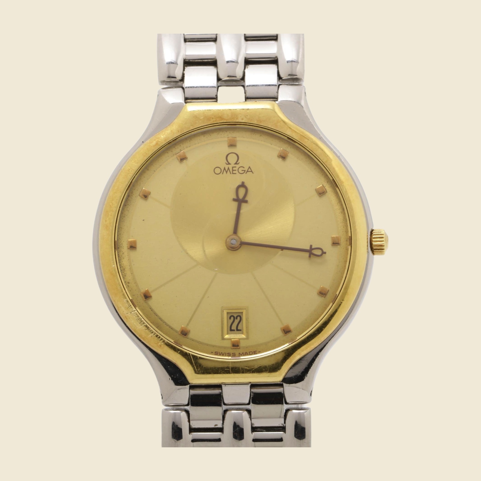 Orologio Omega in acciaio con quadrante champagne, datario a ore 6, lunetta dorata e bracciale a maglie integrato