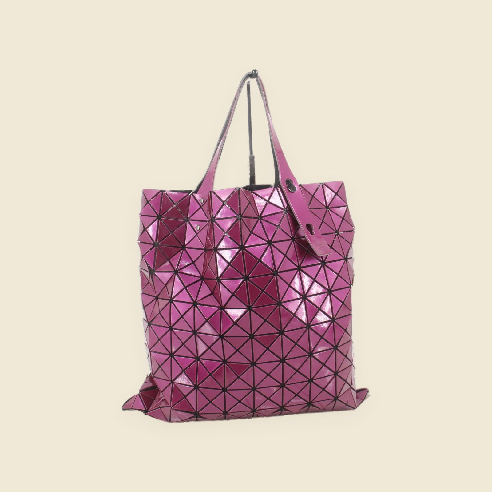 Borsa tote Issey Miyake in PVC lucido fucsia a triangoli, due manici a spalla, vista frontale su fondo bianco