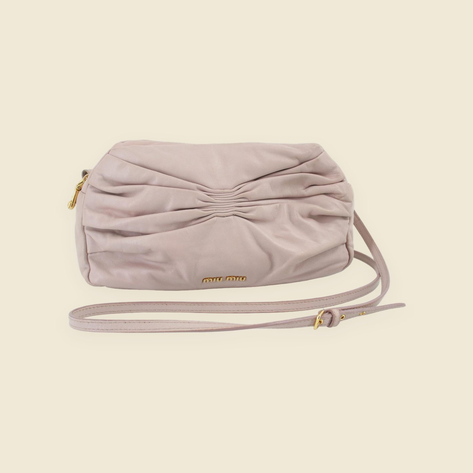 Borsa a spalla Miu Miu in pelle rosa polvere, con pieghe frontali, logo e ferramenta dorati, vista frontale