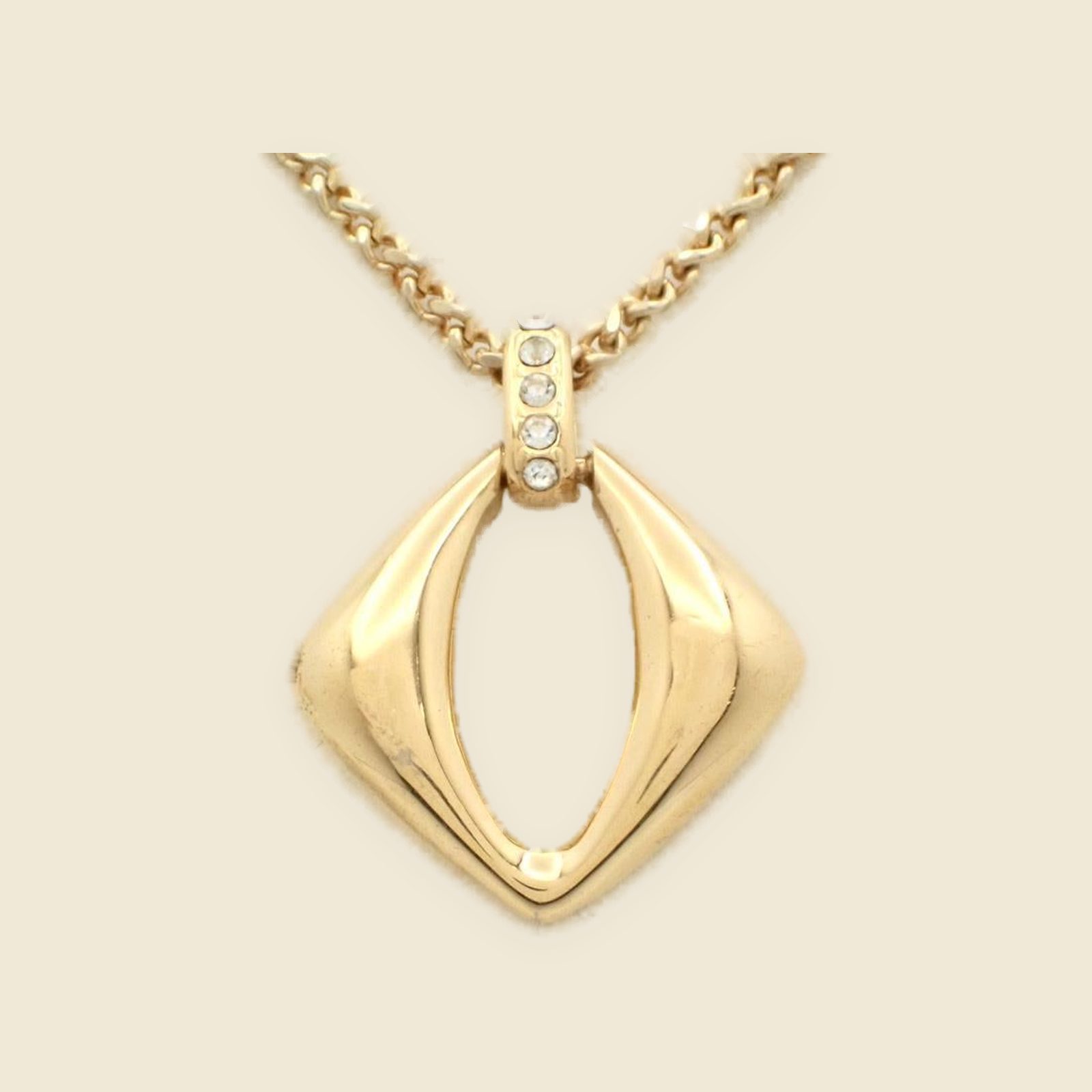 Collana Yves Saint Laurent in metallo dorato con pendente a losanga traforata e strass, vista frontale