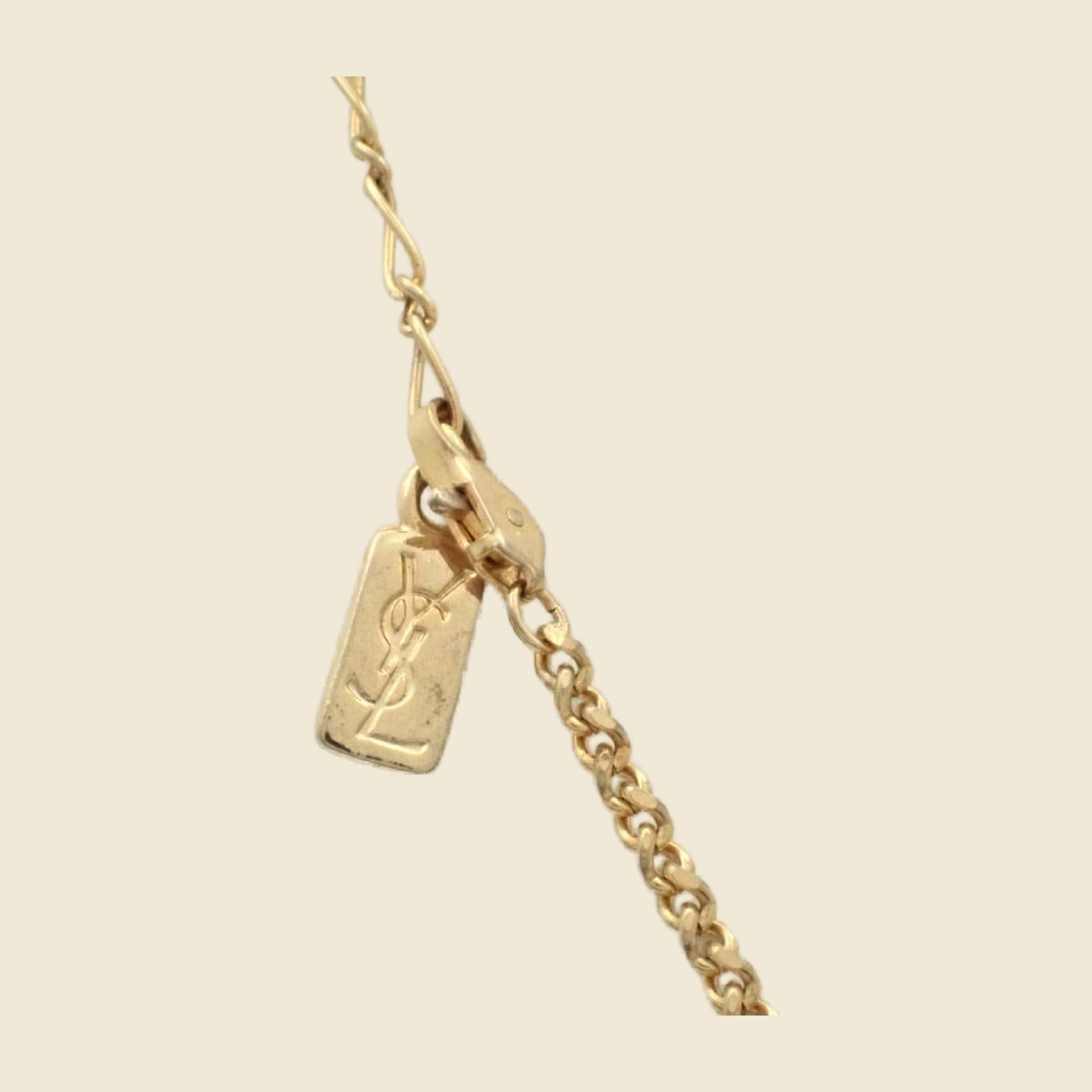 Collana Yves Saint Laurent in metallo dorato con pendente a losanga traforata e strass, vista su busto espositore — vista 2