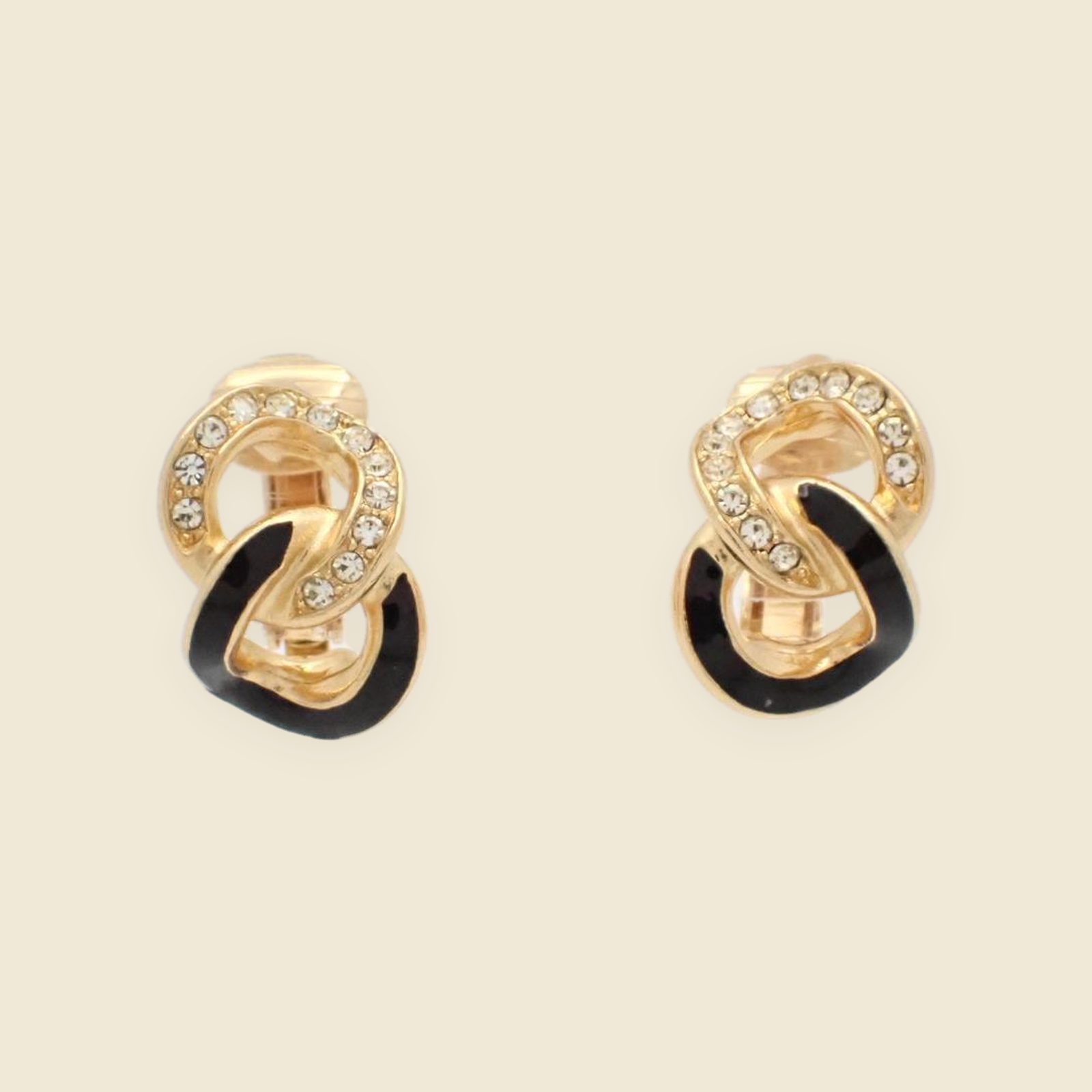 Coppia di orecchini a clip Christian Dior a nodo, in metallo dorato con smalto nero e strass, vista frontale