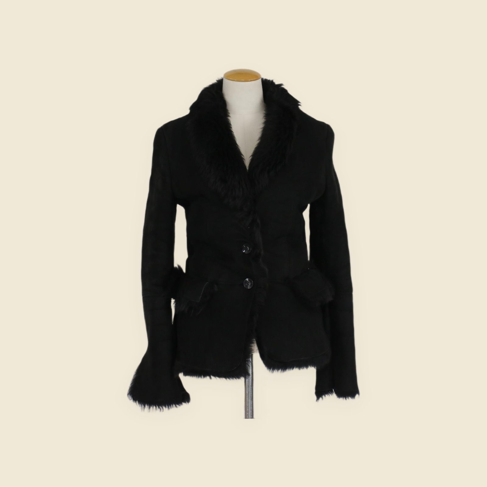 Cappotto Gucci in montone nero con collo a scialle in vello e chiusura a due bottoni, vista frontale su manichino