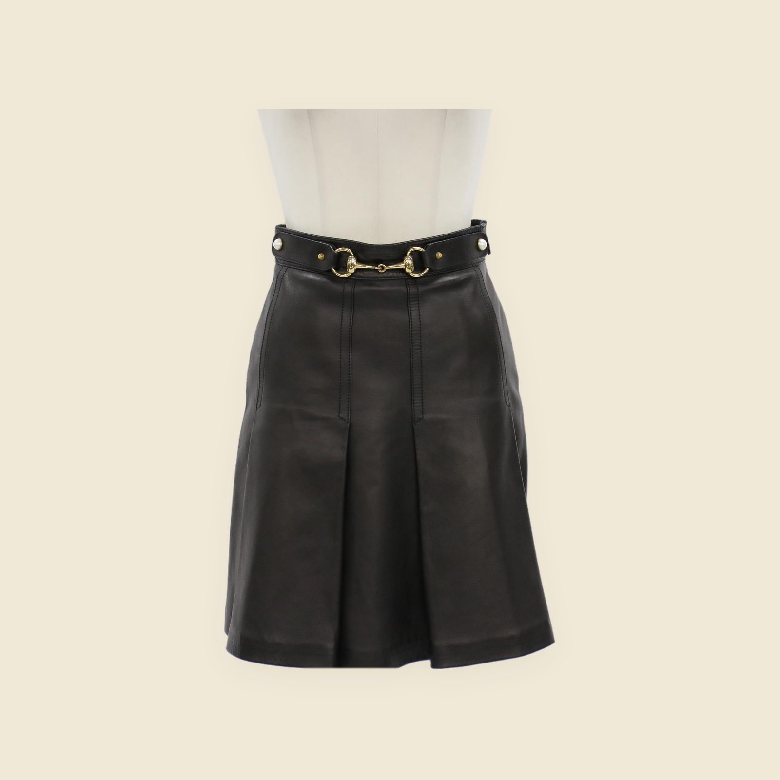 Gonna Gucci in pelle nera a vita alta, con morsetto dorato, cintura con borchie e perle e linea svasata