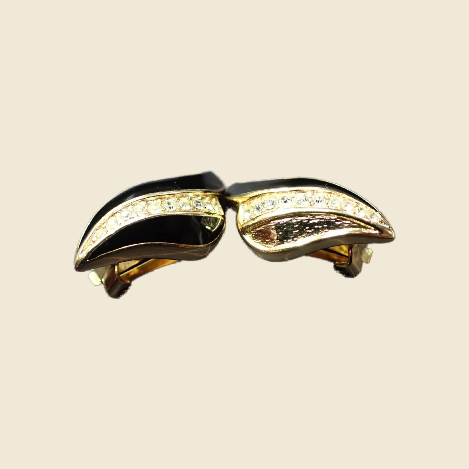 Orecchini a clip Christian Dior a foglia ondulata in metallo dorato, smalto nero e pavé di strass, fondo neutro — vista 3