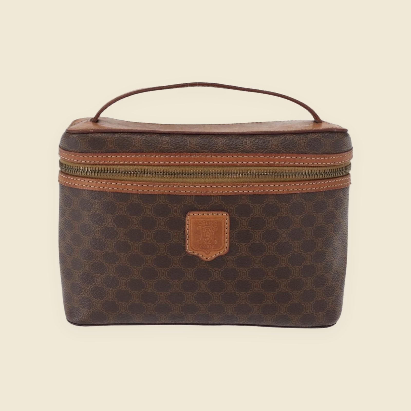 Borsa vanity Celine in tela monogramma marrone e pelle, manico superiore e zip dorata, vista frontale su fondo bianco
