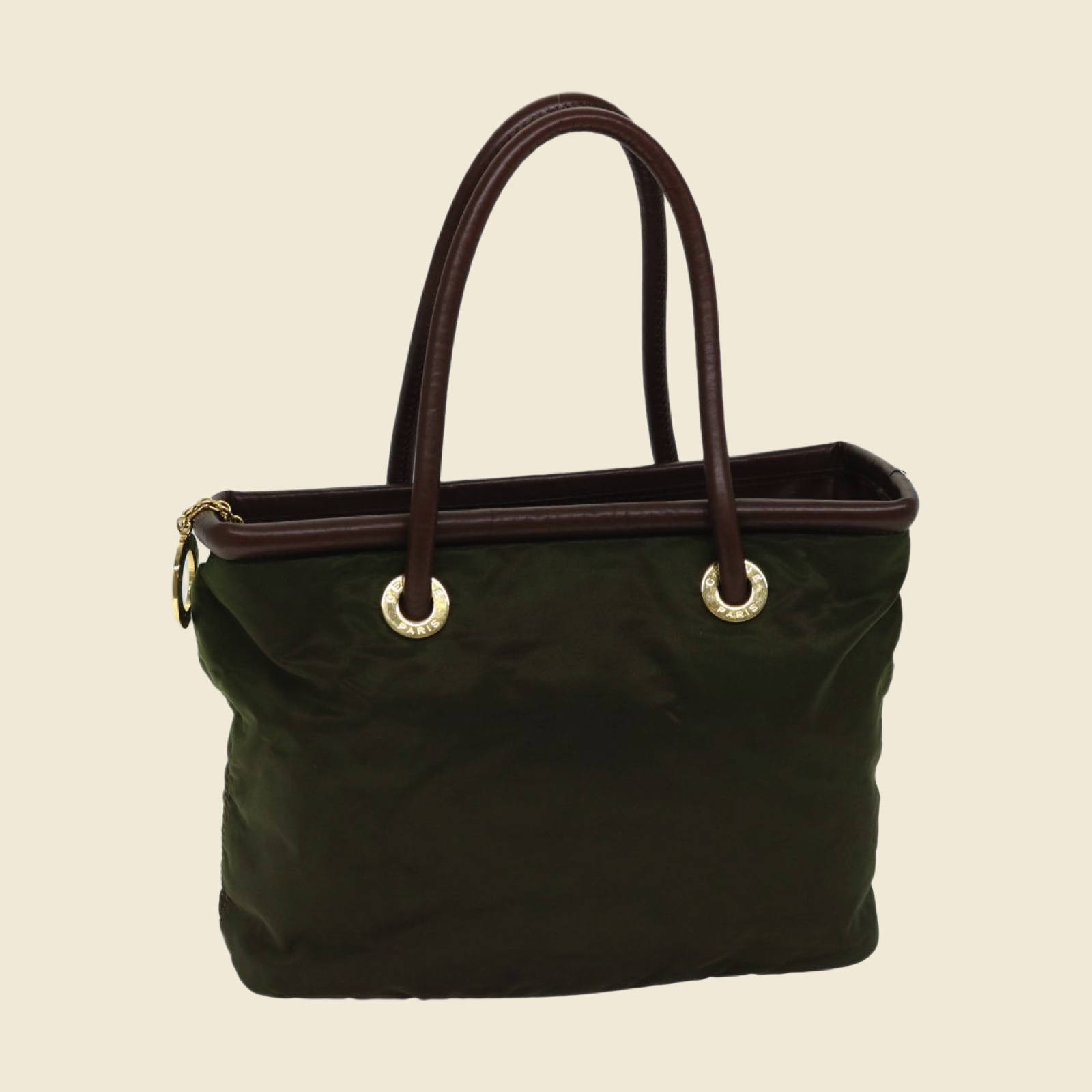 Borsa a mano Celine in tessuto verde oliva con manici in pelle marrone e anelli dorati, vista di tre quarti su fondo bianco