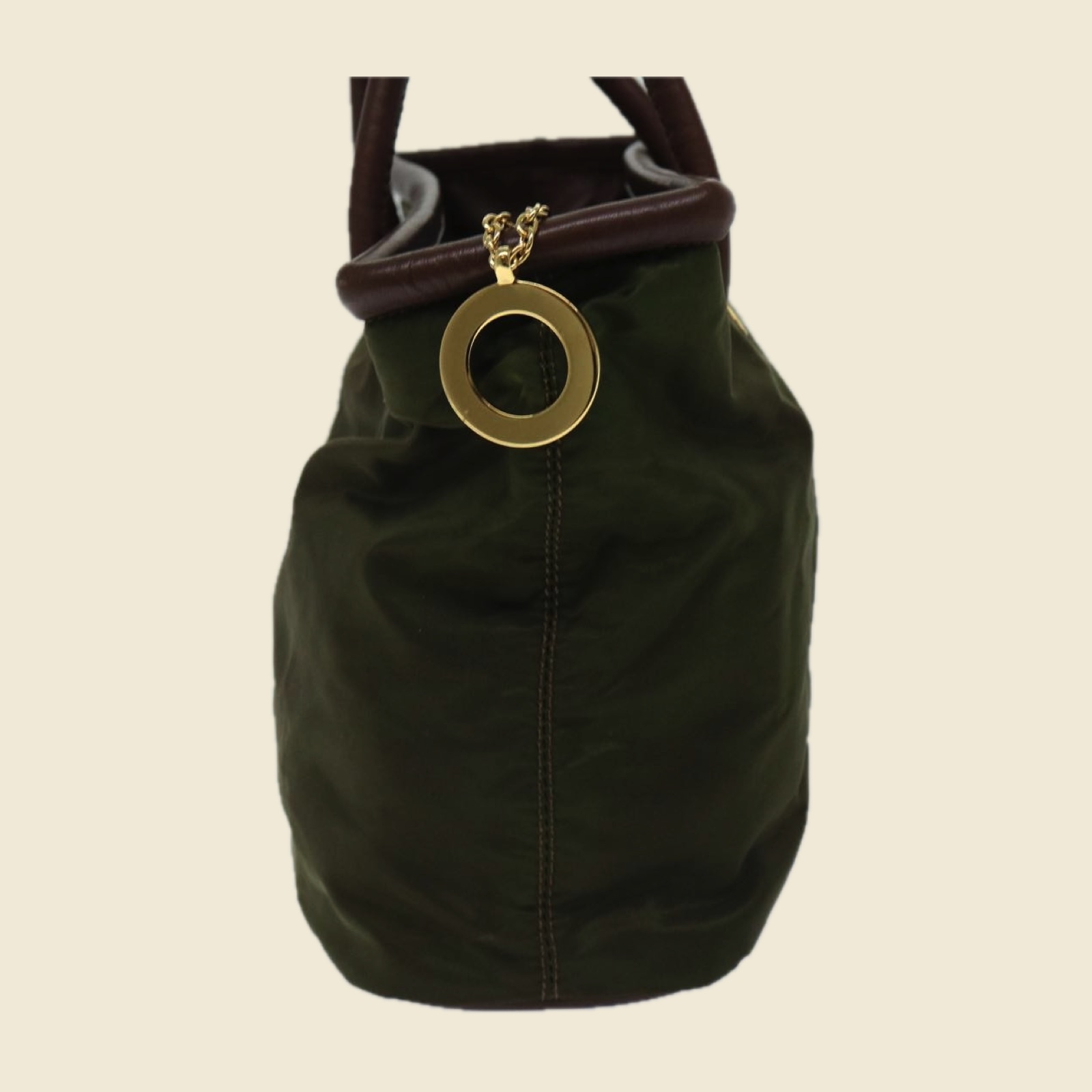 Borsa a mano Celine in tessuto verde oliva con manici in pelle marrone e anelli dorati, vista di tre quarti su fondo bianco — vista 3