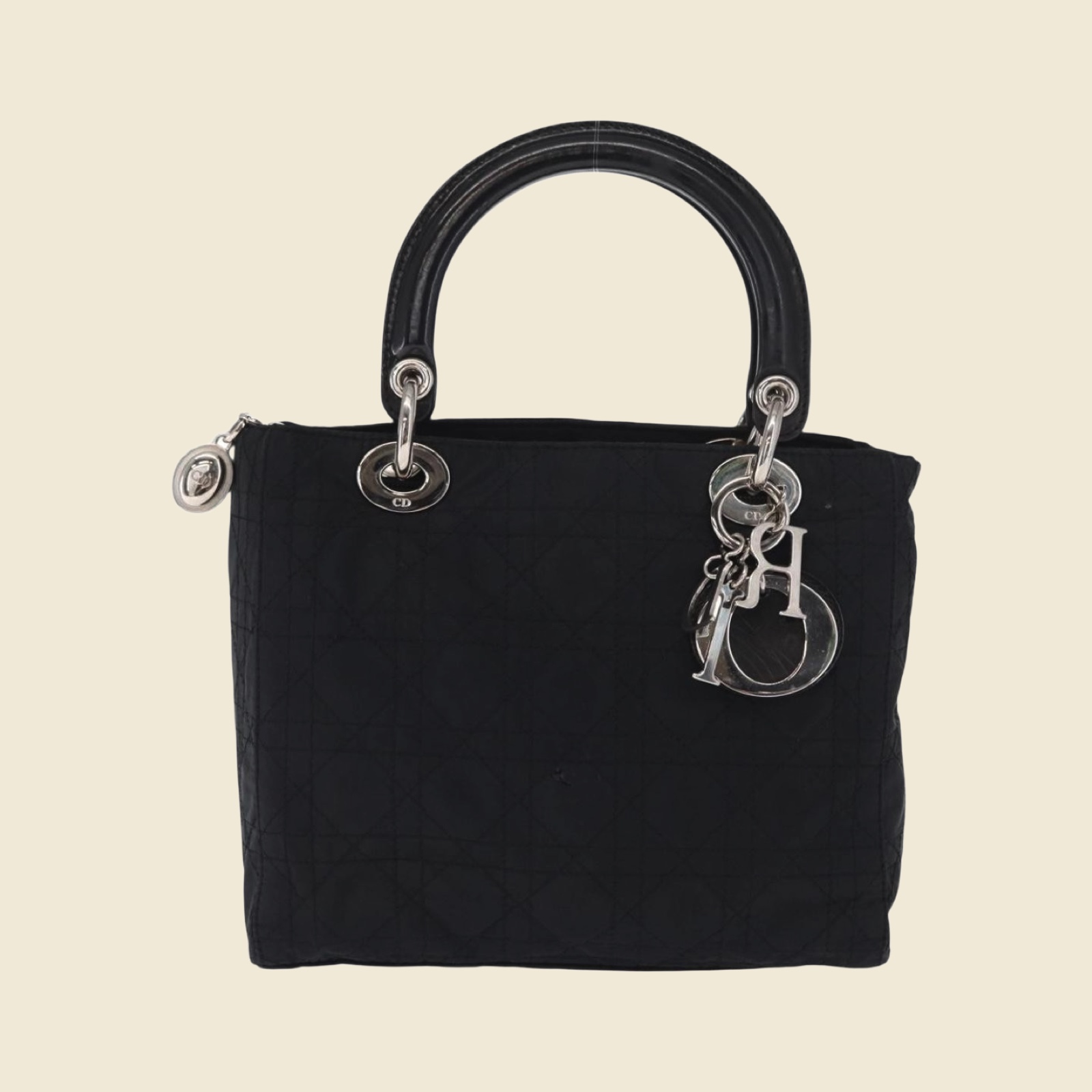 Borsa a mano Christian Dior in nylon nero trapuntato Cannage, doppio manico e ciondoli argentati, vista di tre quarti su fondo bianco — vista 2