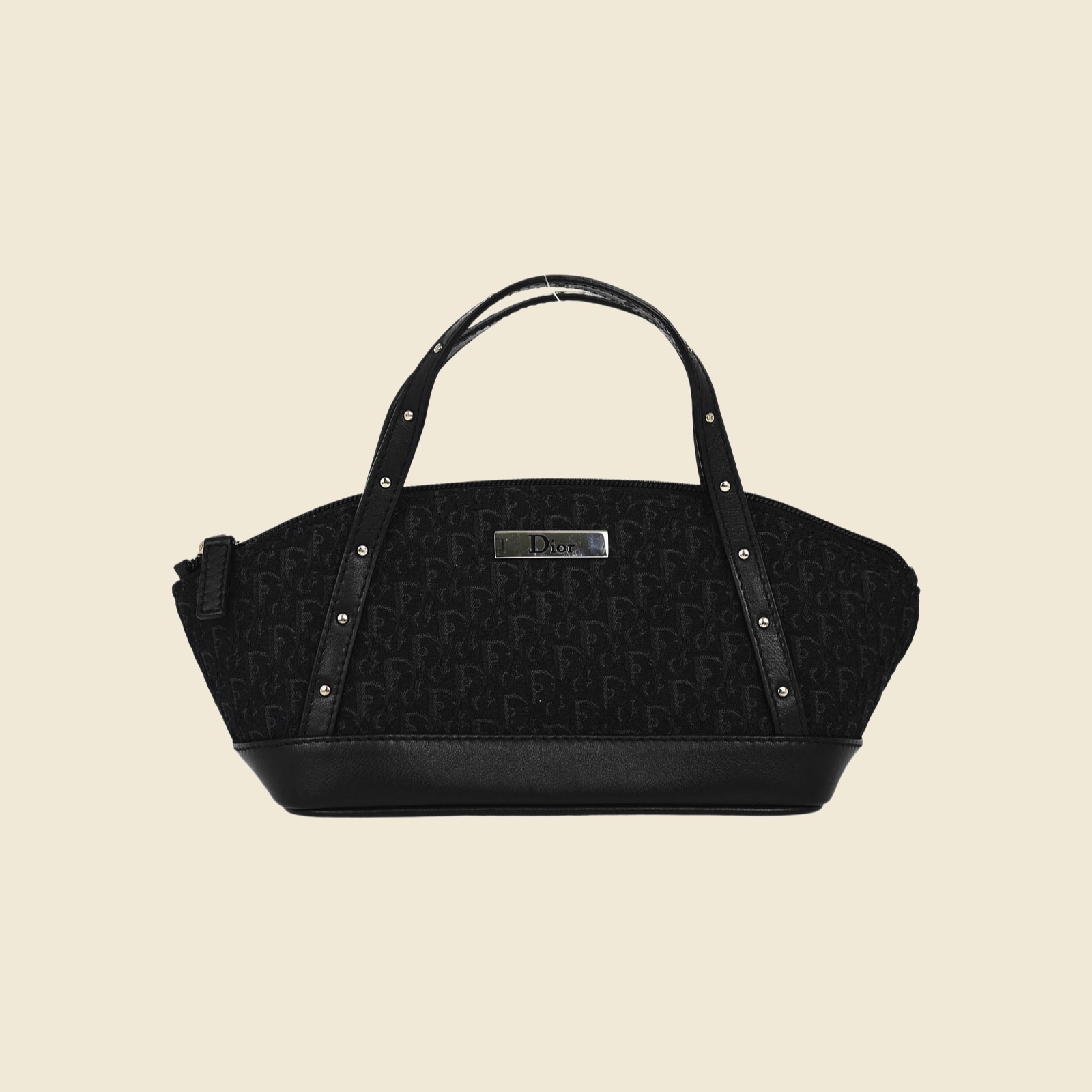 Borsa a mano Christian Dior in tela monogramma nera e pelle, doppi manici con borchie argentate, vista frontale su fondo bianco