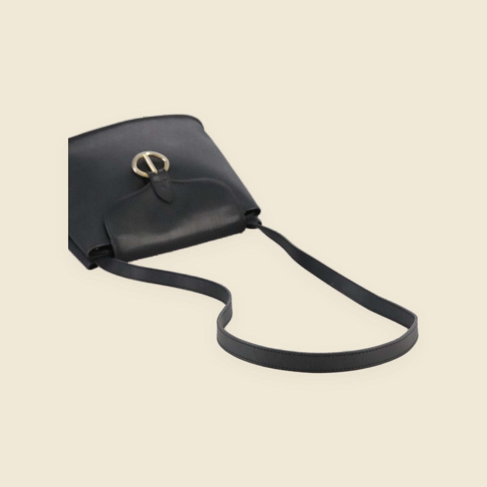 Borsa a tracolla Christian Dior in pelle nera con anello dorato sulla patta, vista di tre quarti su fondo neutro — vista 3