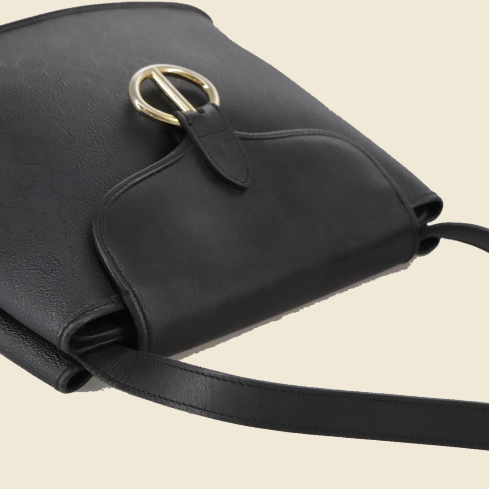 Borsa a tracolla Christian Dior in pelle nera con anello dorato sulla patta, vista di tre quarti su fondo neutro — vista 4