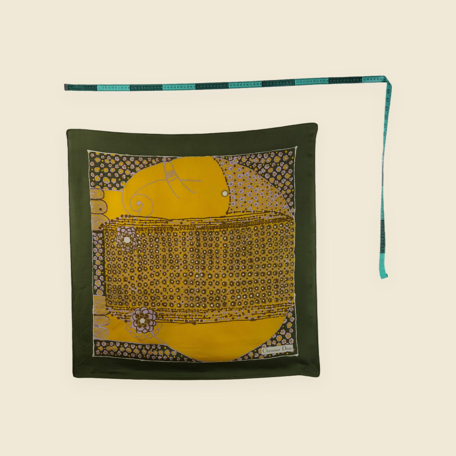 Foulard quadrato Christian Dior in seta, bordo verde oliva e stampa floreale gialla, disteso su fondo chiaro