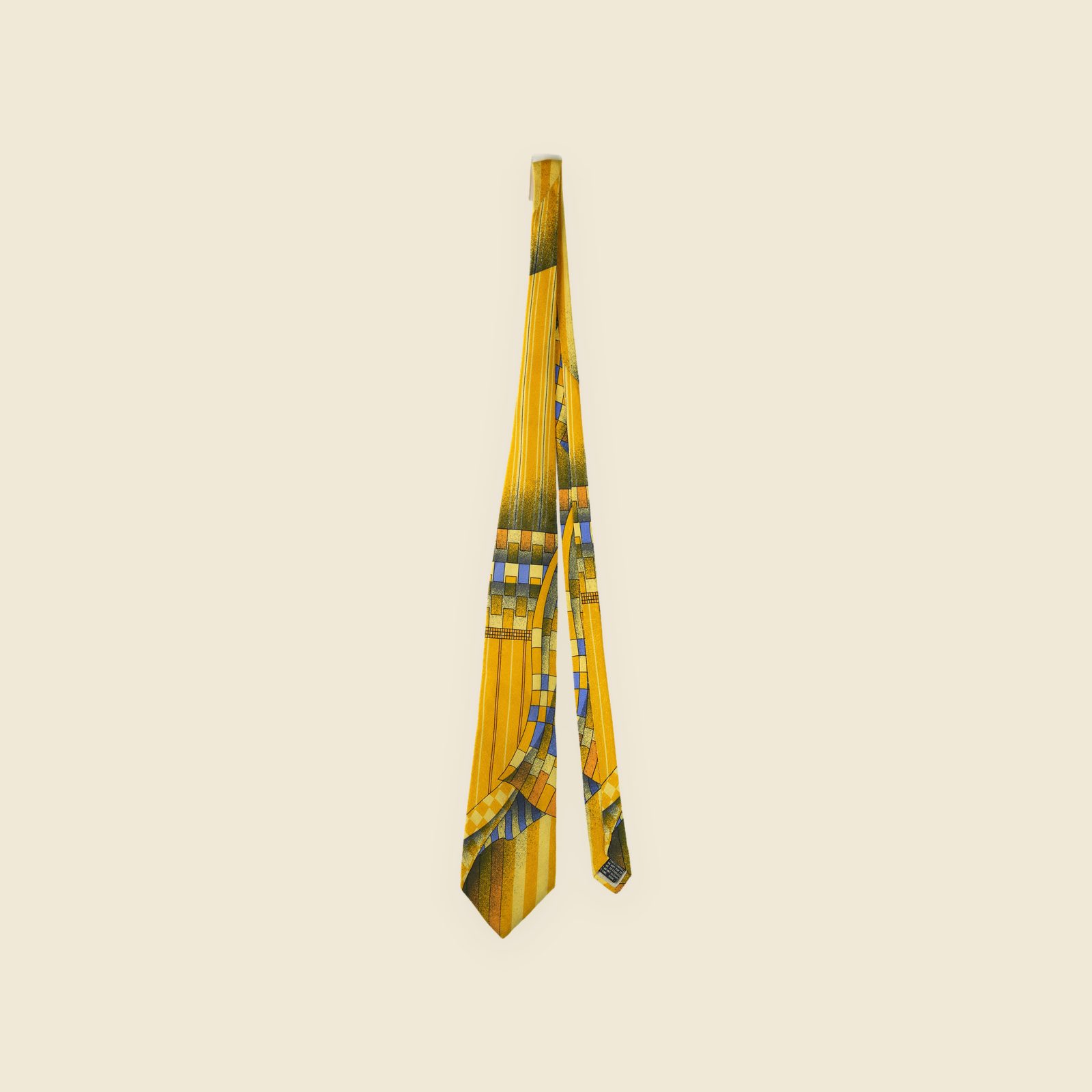 Cravatta Gianni Versace in seta giallo senape con stampa geometrica astratta blu e ruggine, su fondo bianco