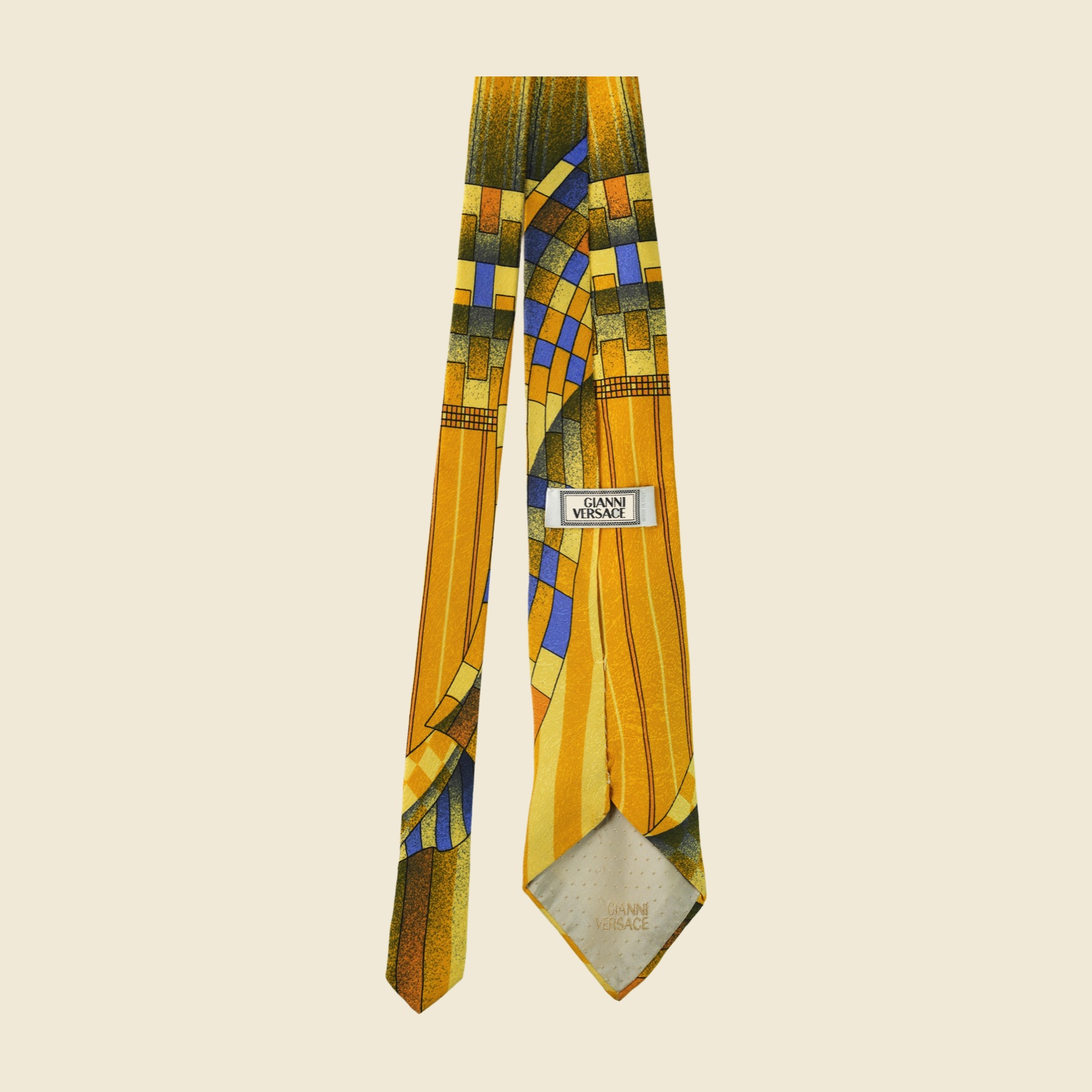 Cravatta Gianni Versace in seta giallo senape con stampa geometrica astratta blu e ruggine, su fondo bianco — vista 3