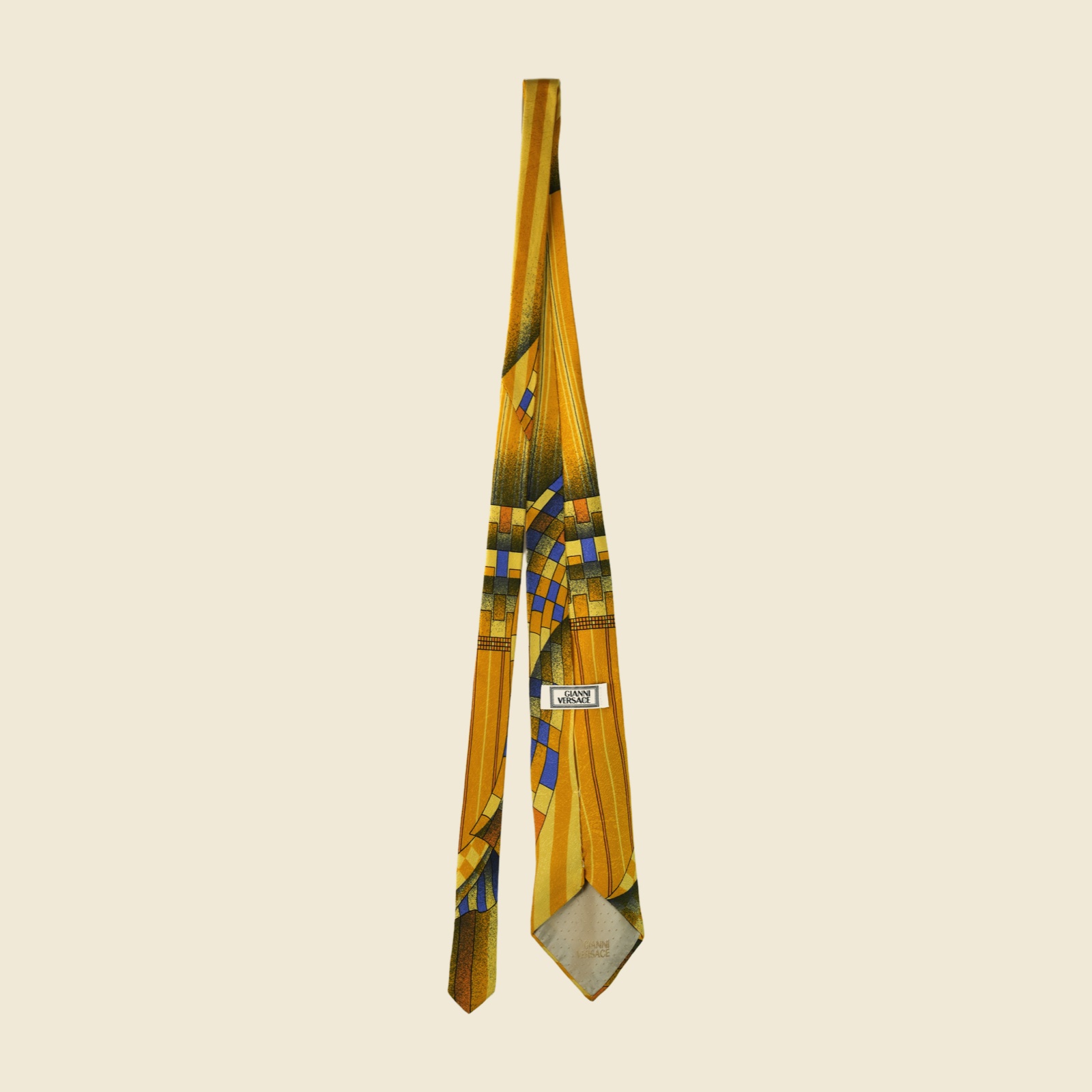 Cravatta Gianni Versace in seta giallo senape con stampa geometrica astratta blu e ruggine, su fondo bianco — vista 4