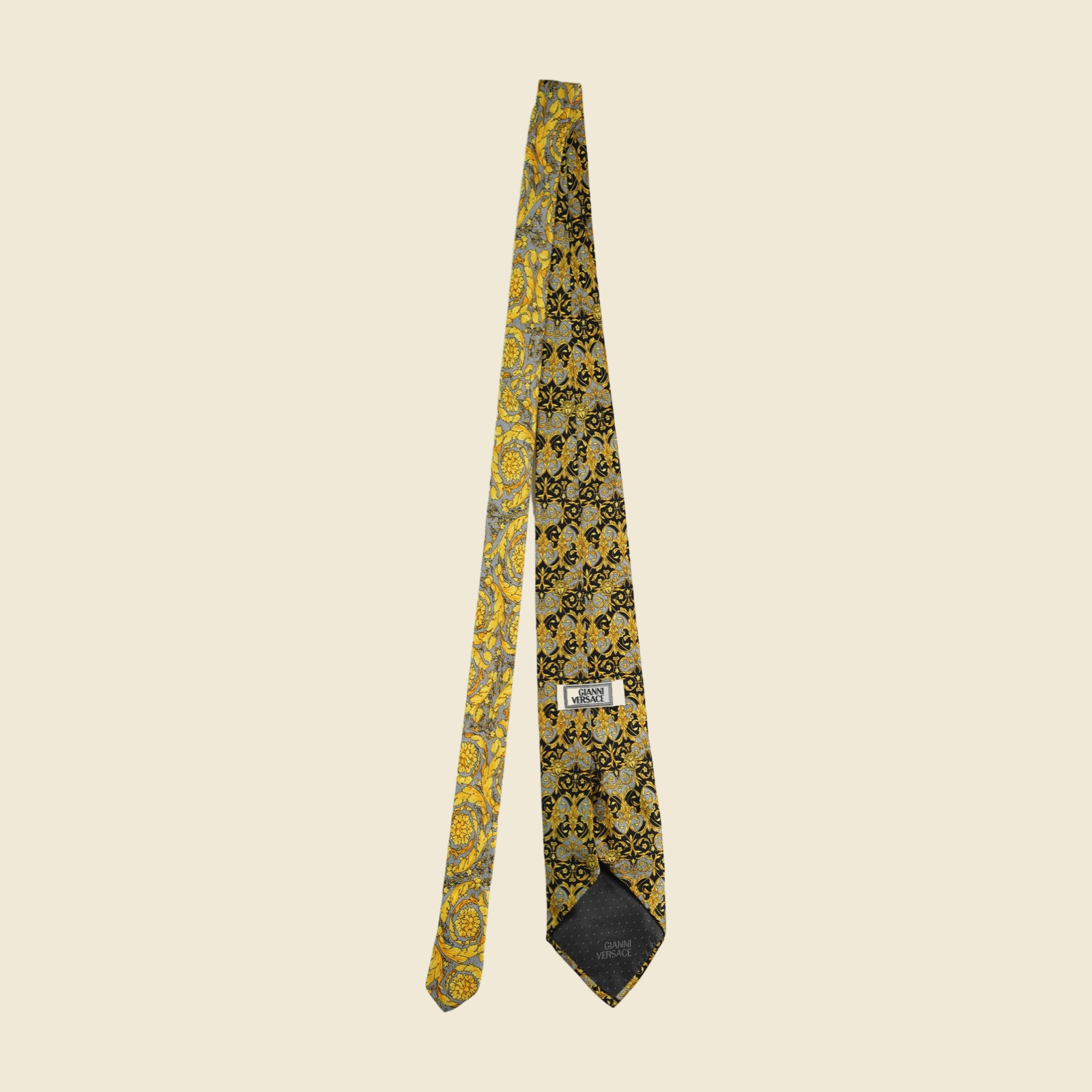 Cravatta Gianni Versace barocca a pannello, volute d'acanto e mascheroni in oro su fondo nero e grigio argento, vista frontale su fondo neutro — vista 3