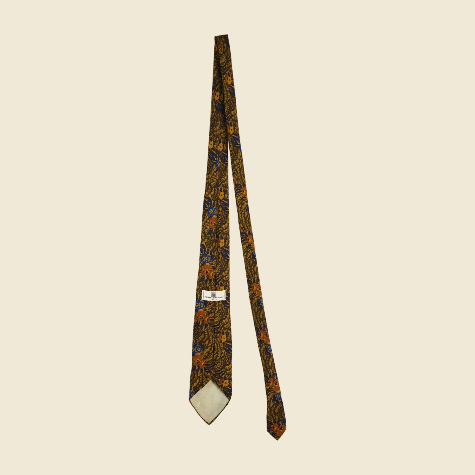Cravatta Pierre Balmain in seta, twill stampato a fiori arabescati marrone tabacco e oro ocra, vista frontale su fondo neutro