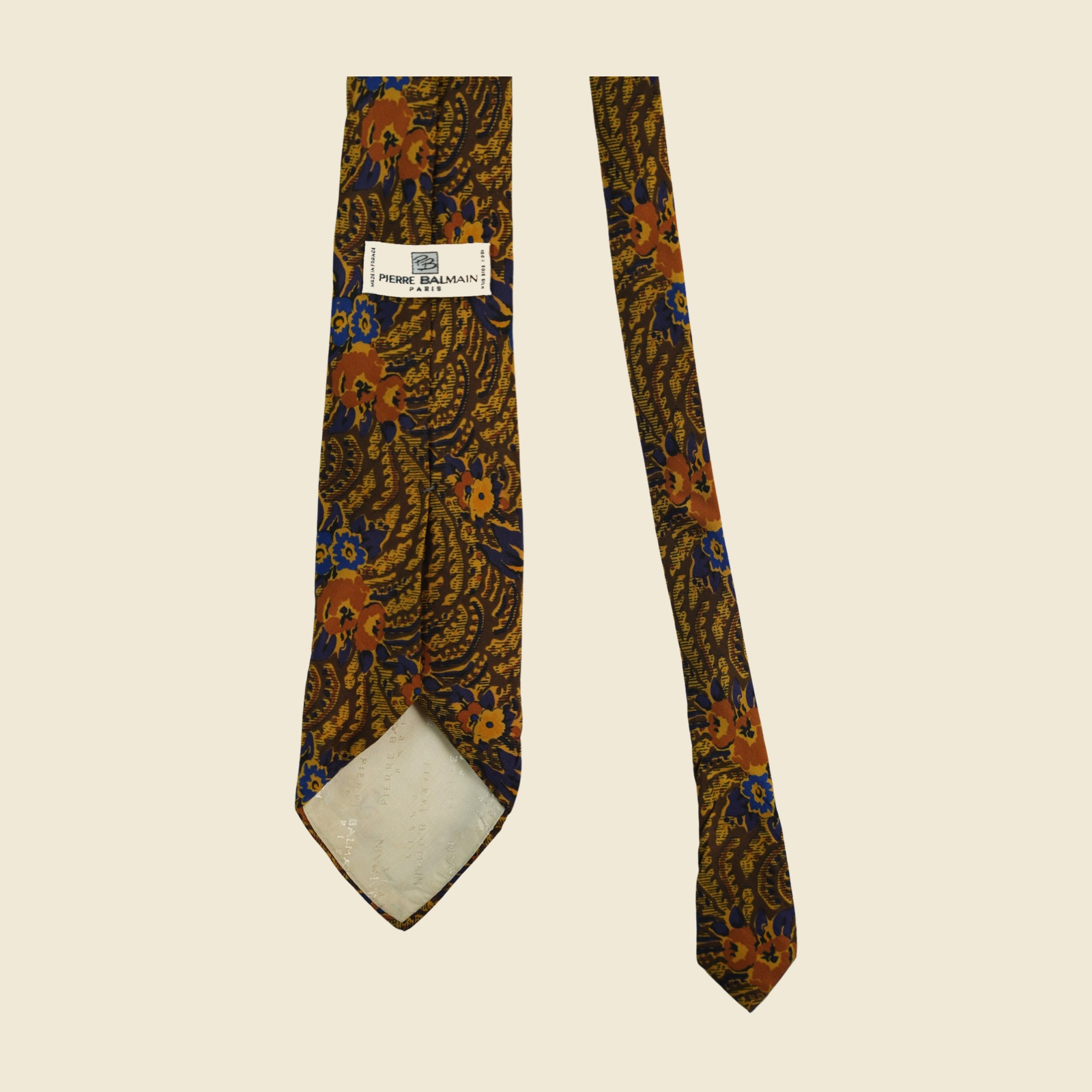 Cravatta Pierre Balmain in seta, twill stampato a fiori arabescati marrone tabacco e oro ocra, vista frontale su fondo neutro — vista 3