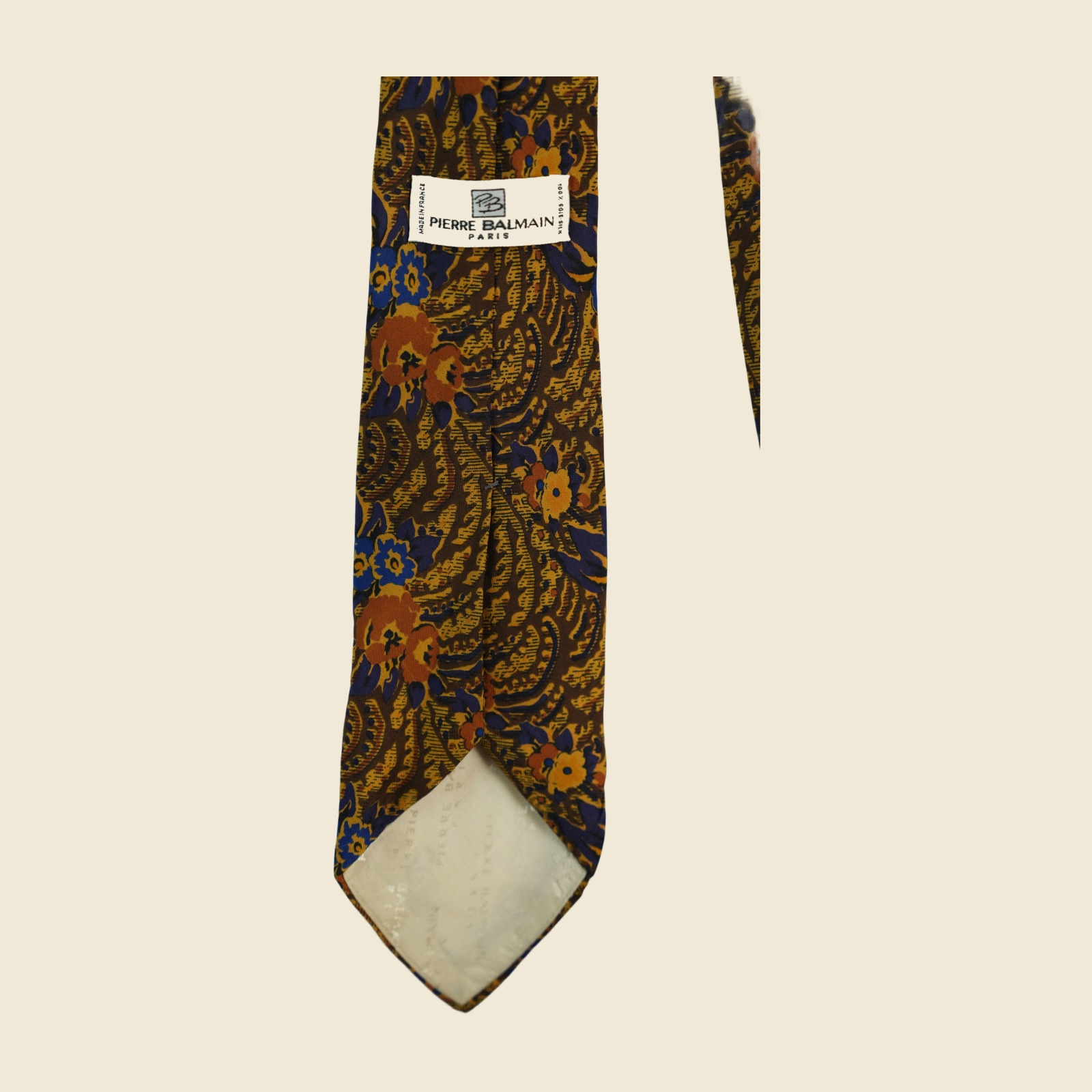 Cravatta Pierre Balmain in seta, twill stampato a fiori arabescati marrone tabacco e oro ocra, vista frontale su fondo neutro — vista 4