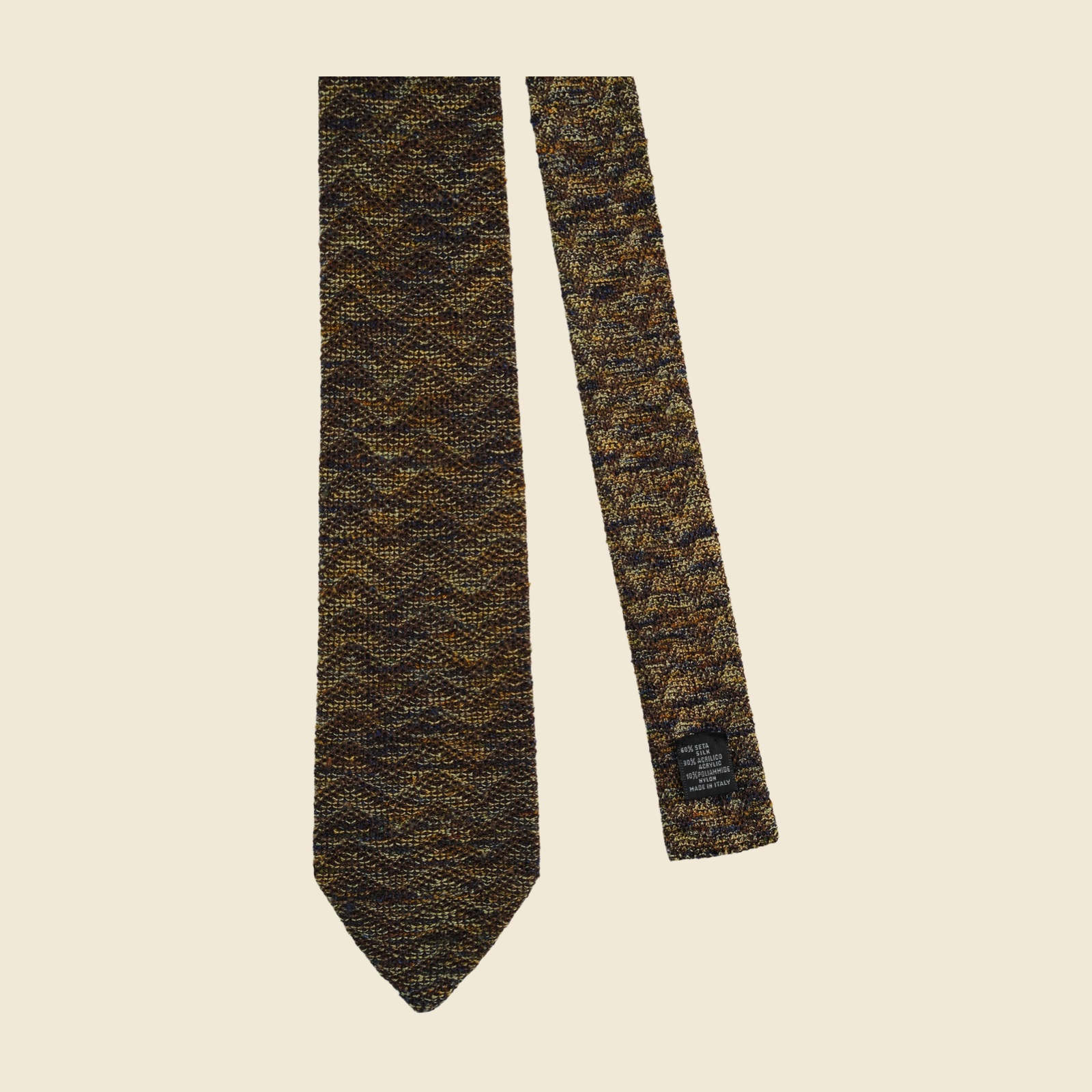 Cravatta a maglia Missoni in seta, acrilico e poliammide, filato bouclé fiammato marrone con oro-ocra, crema e lampi di blu notte, vista frontale su fondo neutro
