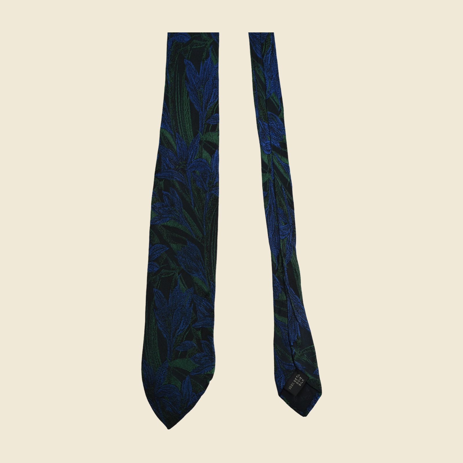 Cravatta Gianni Versace in seta con gigli e foglie lanceolate tessuti a jacquard su blu cobalto, verde smeraldo e nero, vista frontale su fondo neutro — vista 3