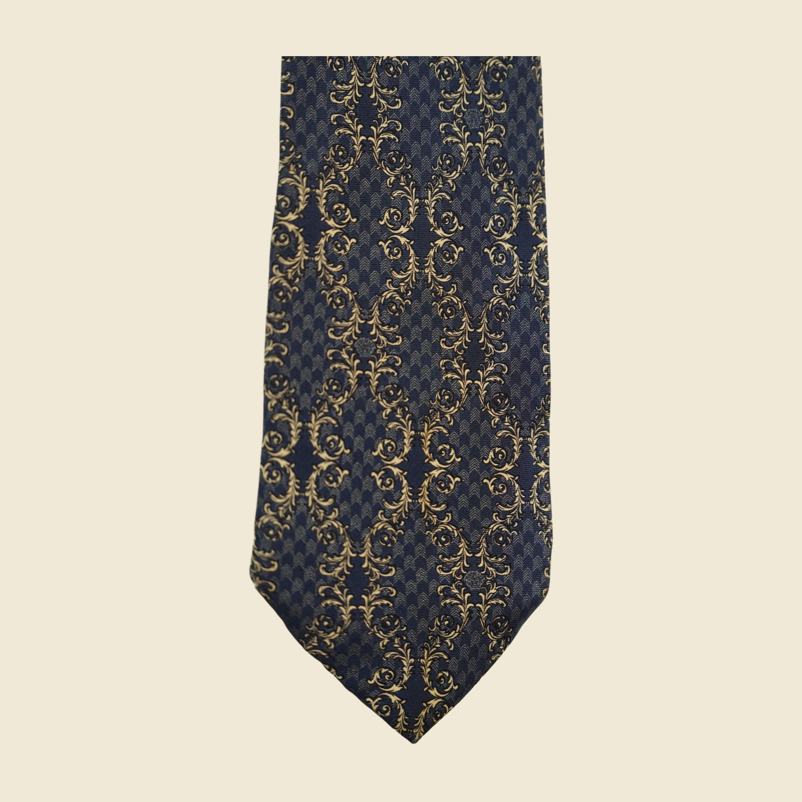 Cravatta Gianni Versace in seta blu navy con tralci d'acanto e volute avorio-oro a fasce diagonali, vista intera in posa piatta — vista 4