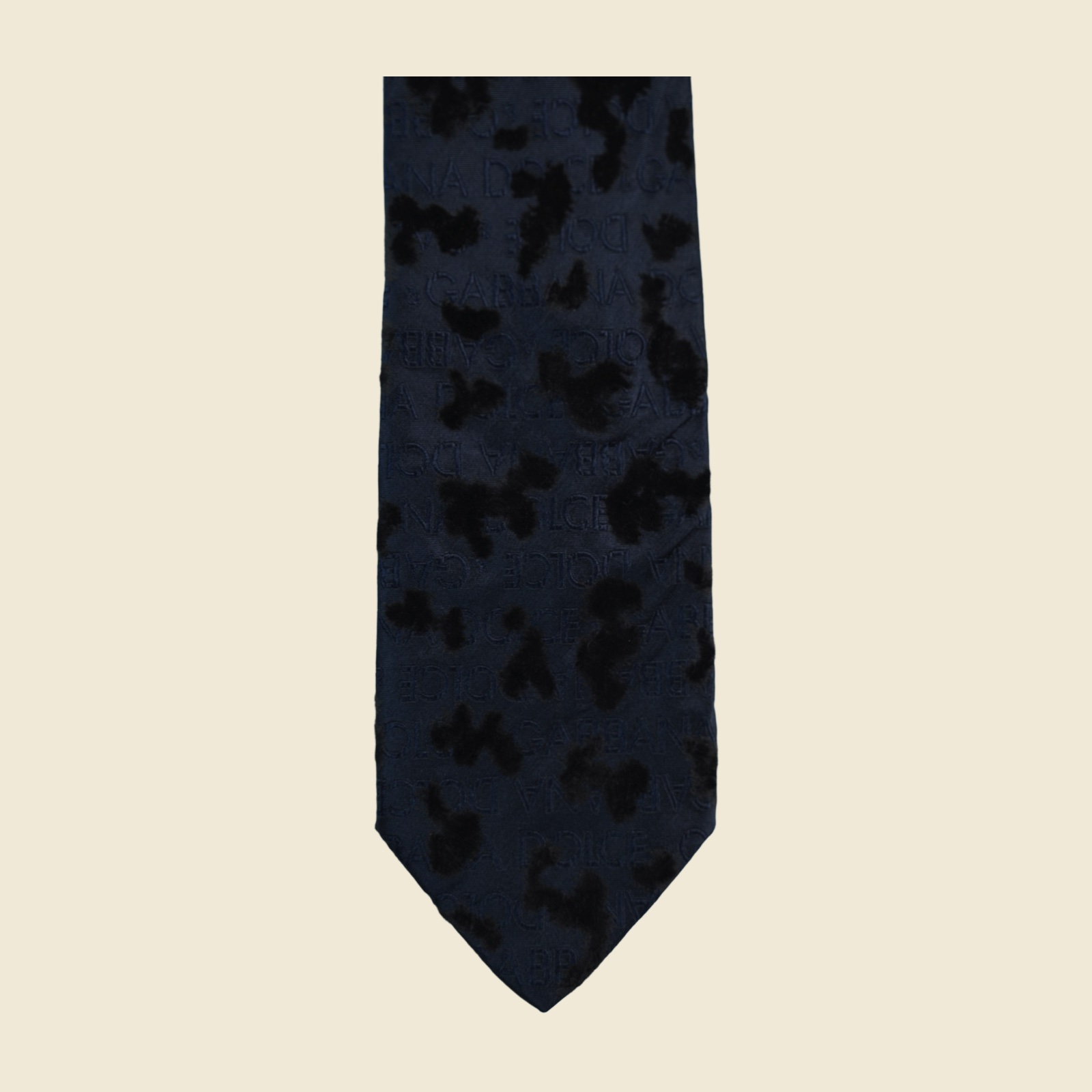 Cravatta Dolce & Gabbana in seta blu notte con macchie di velluto nero in rilievo su fondo jacquard, distesa su fondo neutro — vista 3