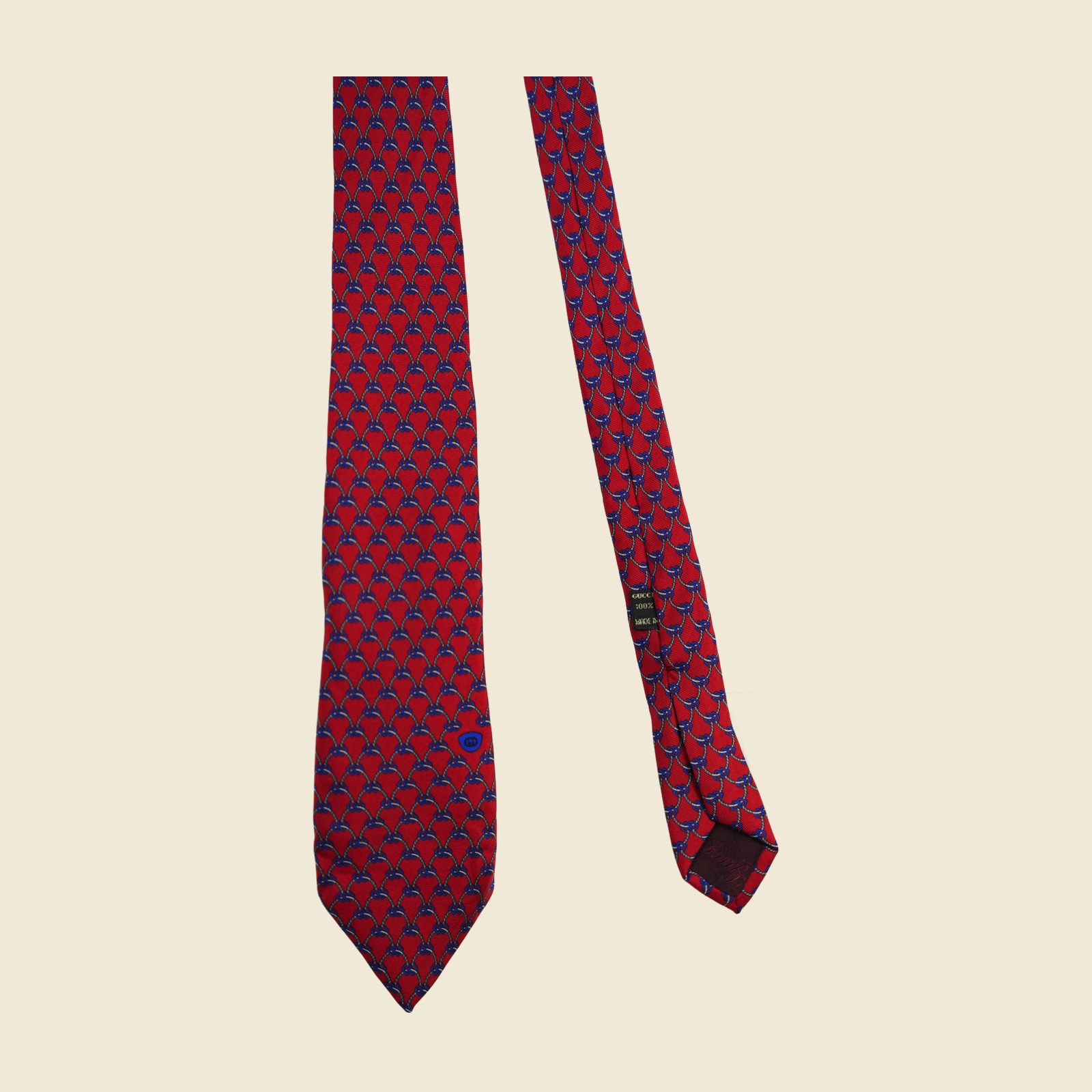 Cravatta Gucci a reticolo di corde e catenelle annodate, grigio-argento e blu su fondo rosso, con medaglione ovale blu con stemma verso la punta larga — vista 3