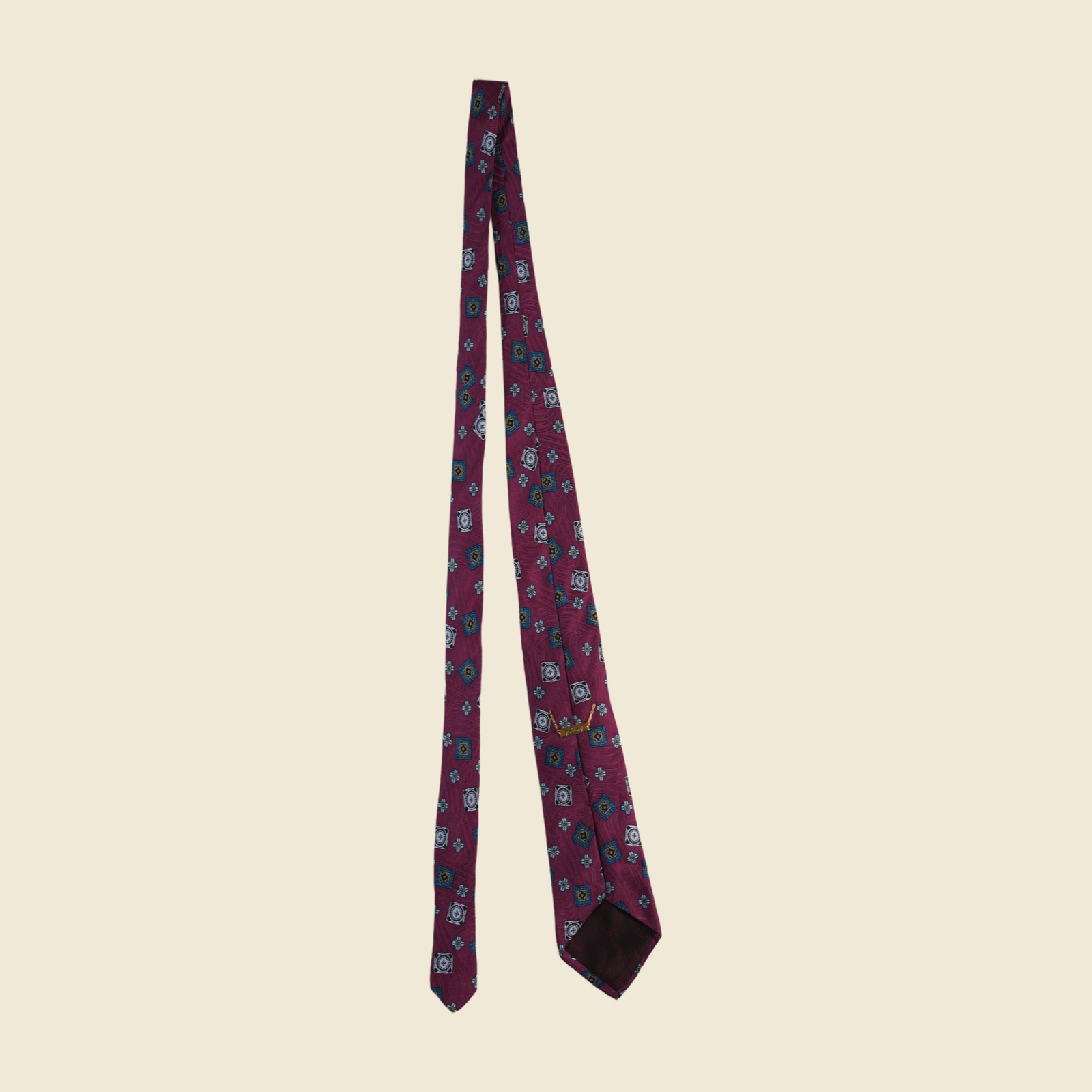 Cravatta Brioni in seta magenta prugna con medaglioni jacquard tessuti in oro, azzurro e ottanio, vista frontale su fondo neutro — vista 3