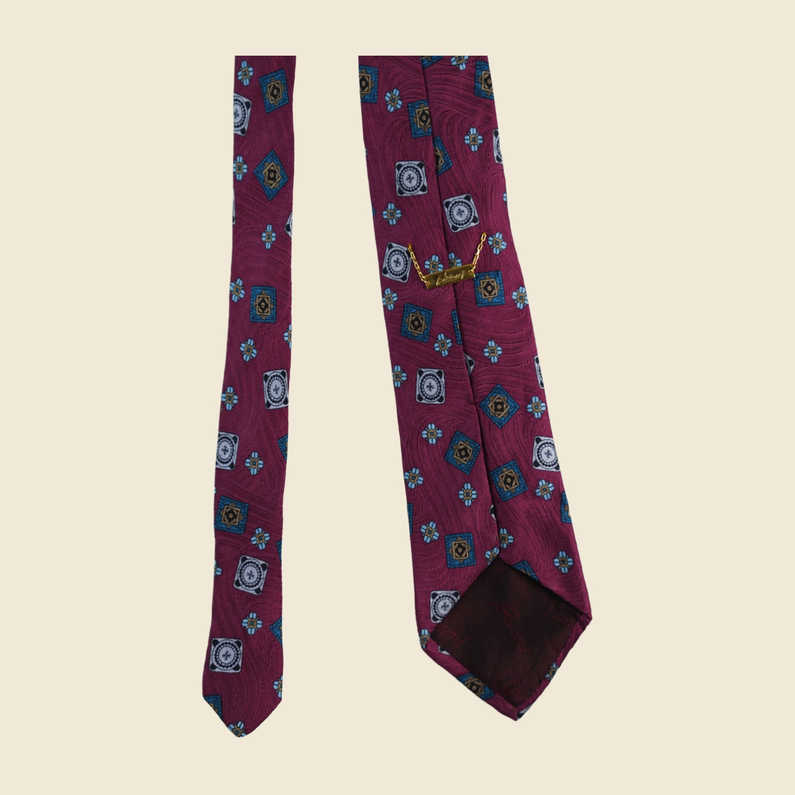 Cravatta Brioni in seta magenta prugna con medaglioni jacquard tessuti in oro, azzurro e ottanio, vista frontale su fondo neutro — vista 4