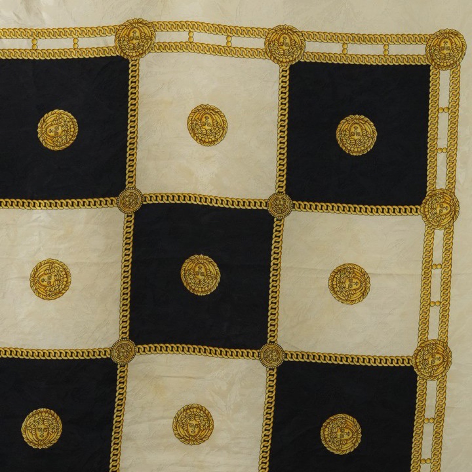 Foulard quadrato in seta disteso, scacchiera barocca di riquadri neri e avorio divisi da una catena groumette dorata, medaglioni a testa femminile coronata, campo avorio con ghirlanda a festoni e cornice nera — vista 3