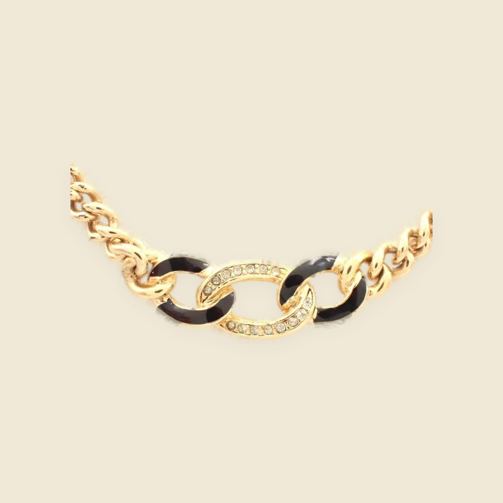 Collana girocollo Christian Dior in metallo dorato, anelli centrali neri con strass, su busto espositore