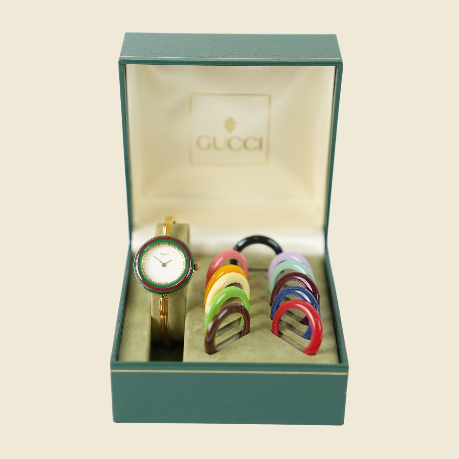 Orologio Gucci dorato con quadrante bianco e ghiera verde e rossa, nella scatola con il corredo di ghiere colorate