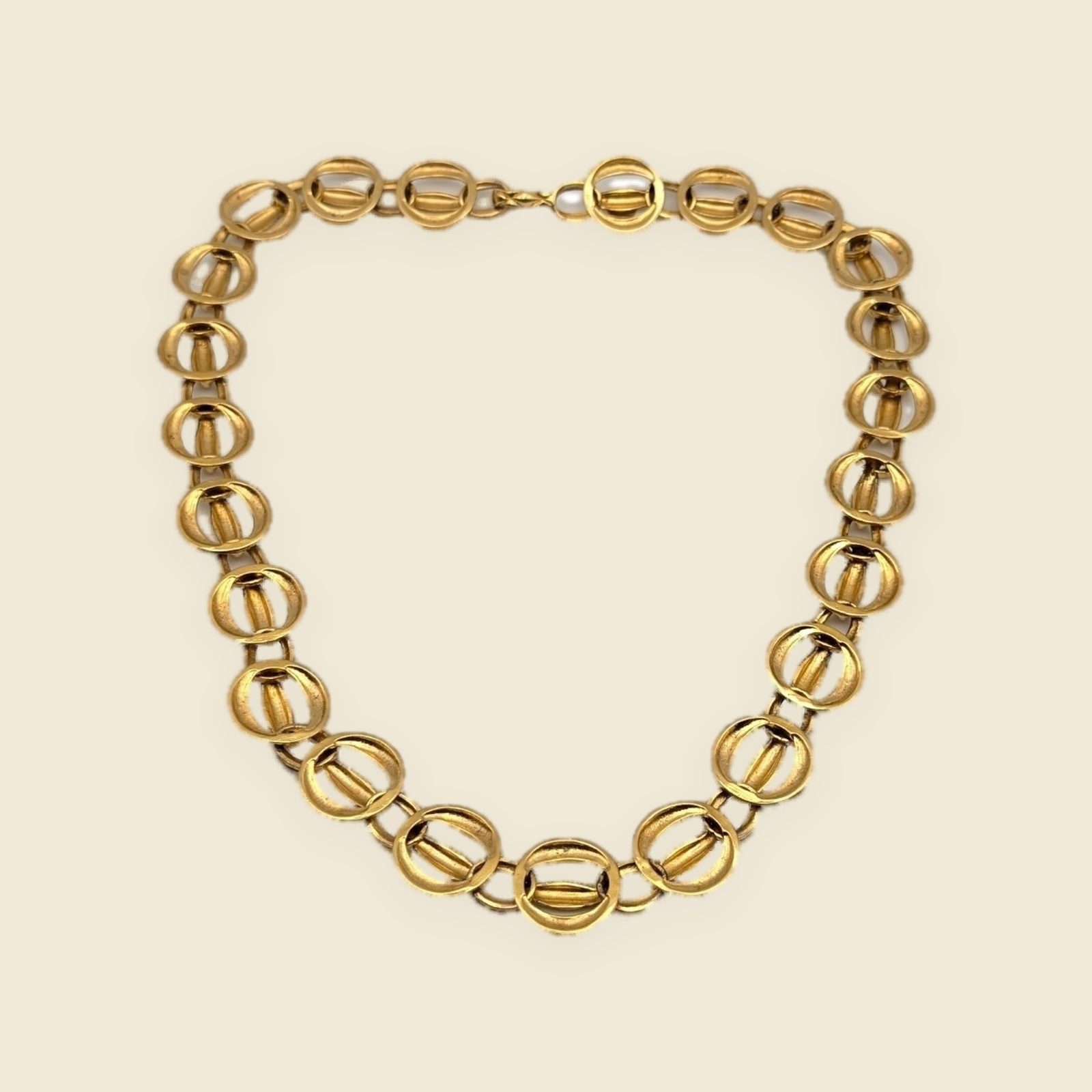 Collana Chanel in metallo dorato a maglie ovali bombate con motivo matelassé e chiusura a gancio, su fondo chiaro