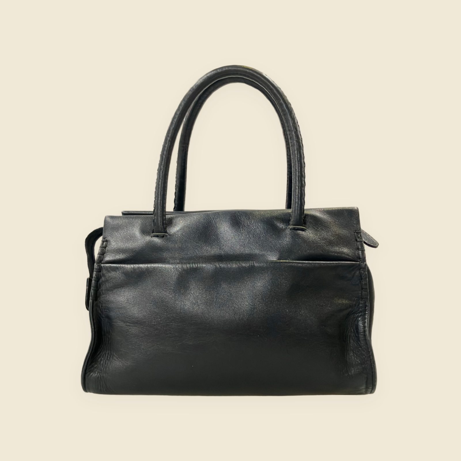 Borsa a mano Kitamura in pelle nera con doppi manici, nodi intrecciati e tasca frontale, vista su fondo neutro — vista 2