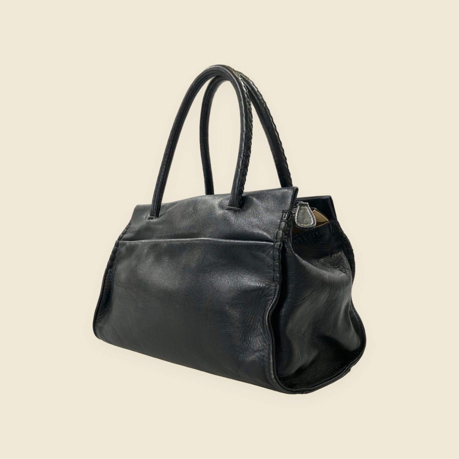 Borsa a mano Kitamura in pelle nera con doppi manici, nodi intrecciati e tasca frontale, vista su fondo neutro — vista 3