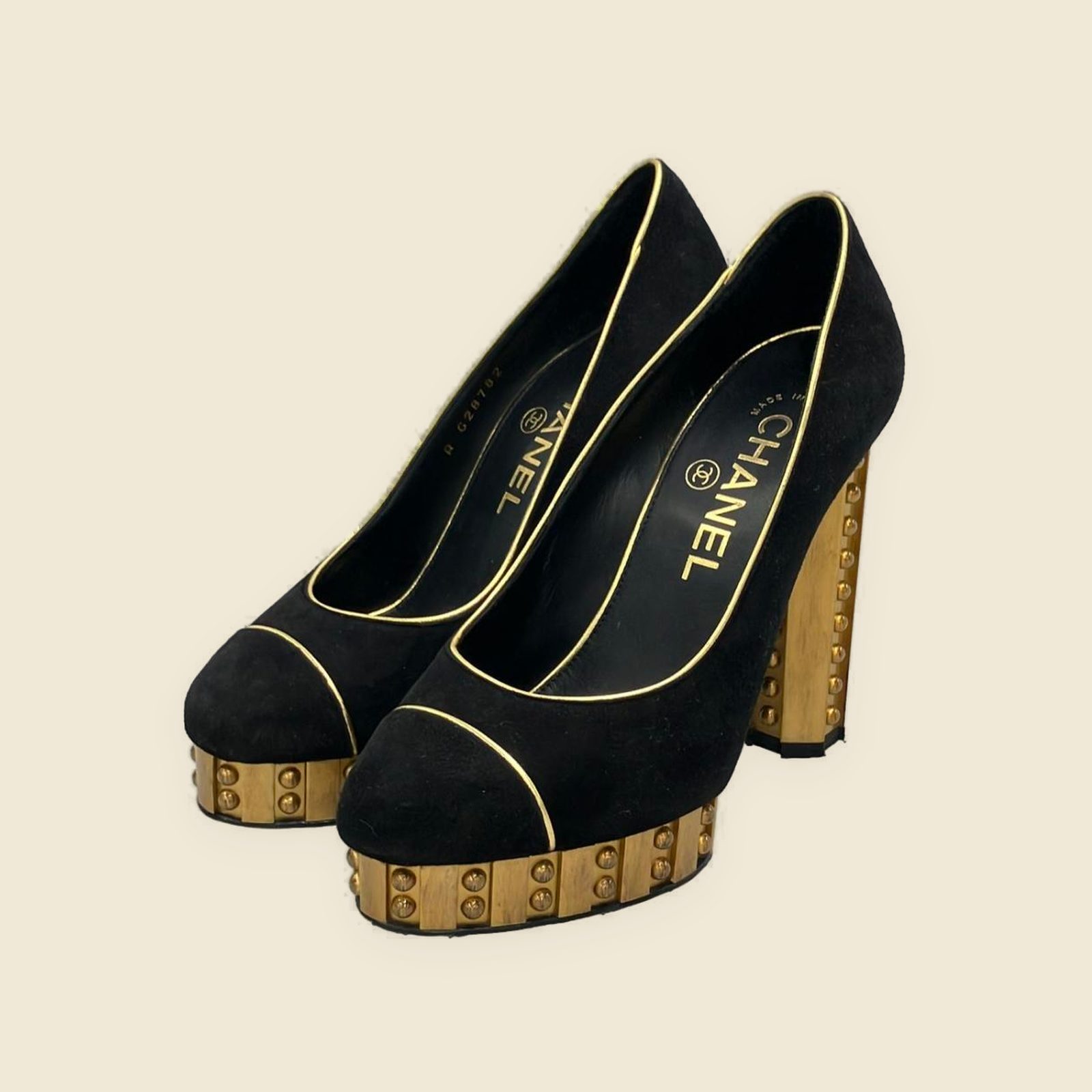Décolleté Chanel in camoscio nero con profili dorati, plateau e tacco largo borchiato, vista di tre quarti